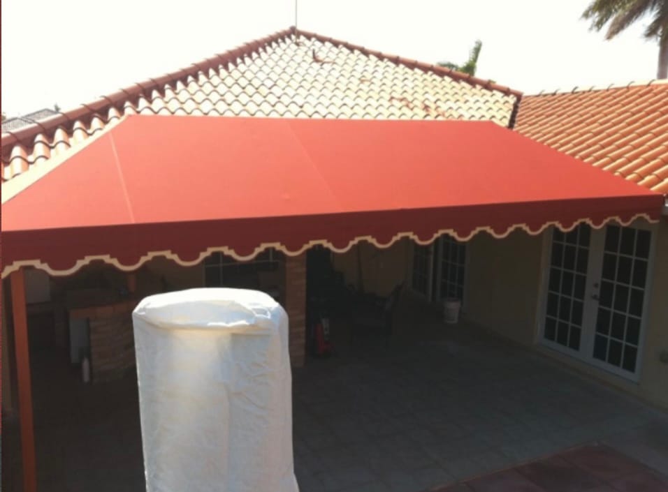 Terracotta canvas patio awning matching a tile roof over a backyard patio
