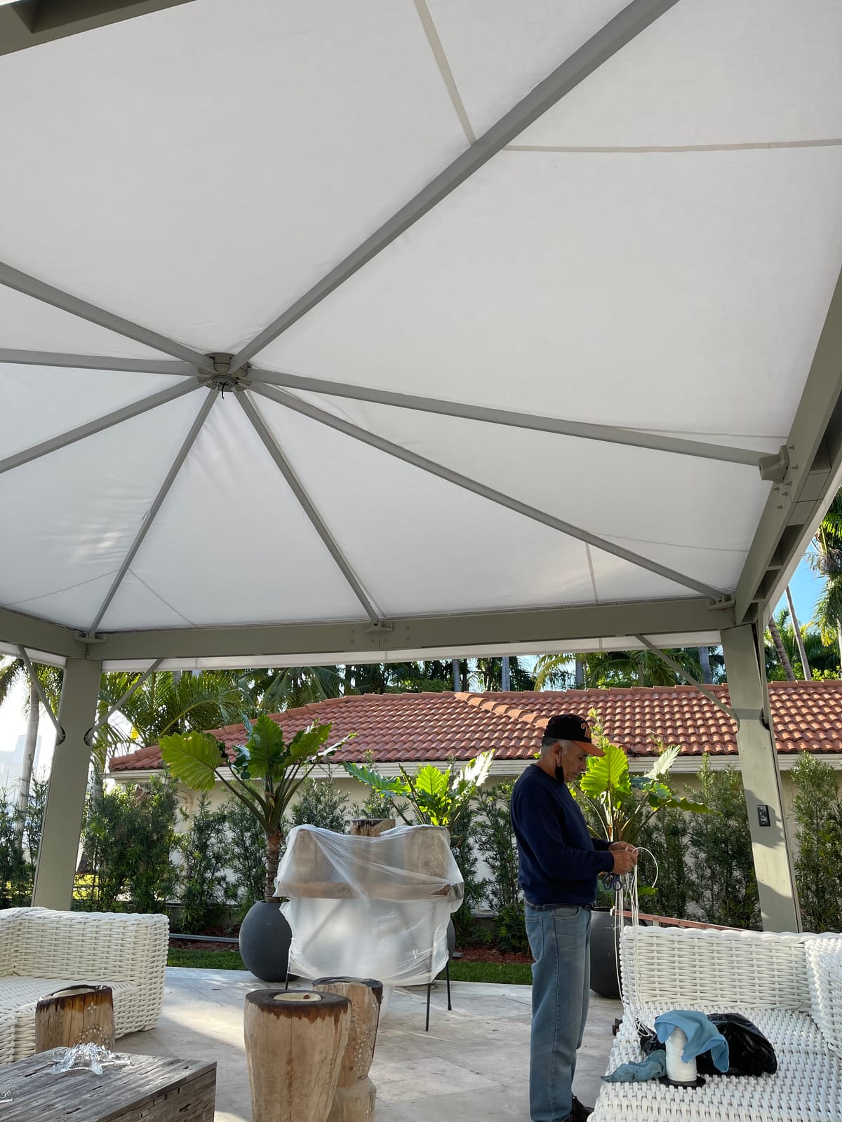 EAB Awnings craftsman installing a custom white gazebo canopy on a patio